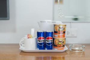 a tray with cans of pepsi on a counter at Nicha Residence Hotel in Bangkok