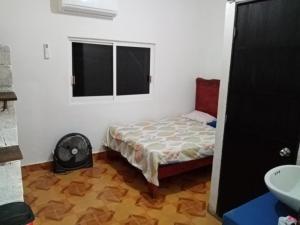 a small bedroom with a bed and a window at Anli in Tonalá