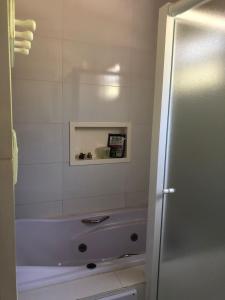 a bathroom with a bath tub and a sink at Casa Maldonado Morada da Praia 4 suítes in Bertioga