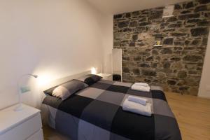 Un dormitorio con una cama con una pared de ladrillos. en Il Giglio - Free Parking, en Como