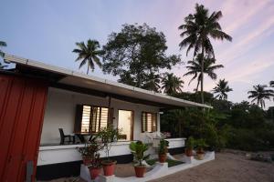 a house with potted plants in front of it at Maria Ocean View in Mararikulam