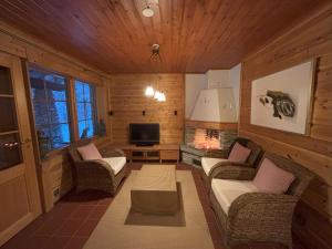 a living room with couches and a tv in a cabin at Villa Vielma in Levi