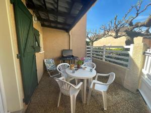 un patio avec une table et des chaises sur un balcon dans l'établissement Maison 2 pièces mezzanine 4 couchages ST CYPRIEN PLAGE SC180-082, à Saint Cyprien Plage
