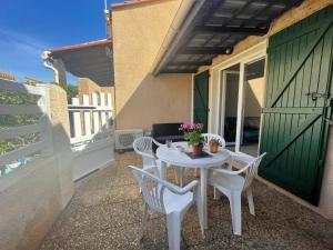 une table blanche et des chaises sur une terrasse dans l'établissement Maison 2 pièces mezzanine 4 couchages ST CYPRIEN PLAGE SC180-082, à Saint Cyprien Plage 9 autres photos