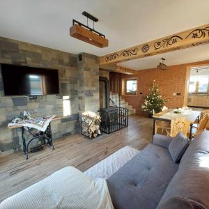 a living room with a couch and a stone wall at Apartamenty Rogoża in Rogożnik