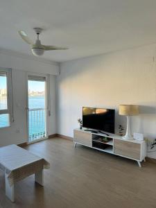salon z telewizorem z płaskim ekranem i kanapą w obiekcie Bonito triplex con increíbles vistas w mieście Benidorm