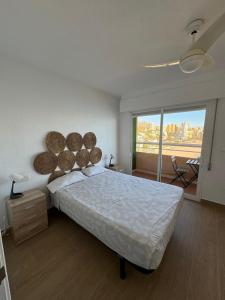 sypialnia z dużym łóżkiem i dużym oknem w obiekcie Bonito triplex con increíbles vistas w mieście Benidorm
