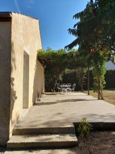 a patio with a table and chairs under an arch at Country house near Nevers in Cours-les-Barres +8 photos