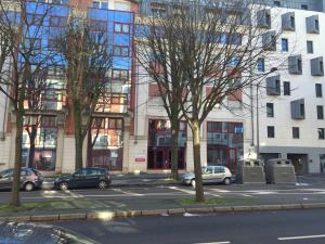 una calle de la ciudad con coches estacionados frente a los edificios en Neoresid - Résidence Saint Marc, en Rouen