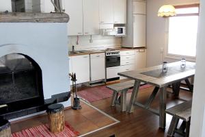a kitchen with a table and a fireplace at Rämäkkä Holidays in Rautalampi