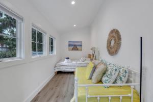 a living room with a yellow couch and windows at The Workshop in Beaufort