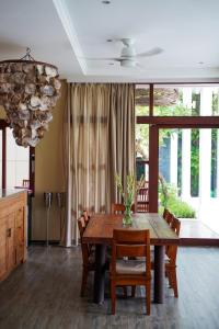 a dining room with a wooden table and chairs at Villa Gita Segara Candidasa in Candidasa