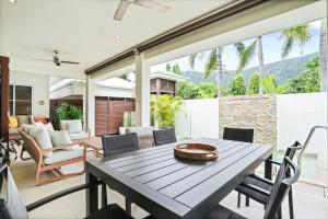 una sala da pranzo con tavolo e sedie di Sunhaven Palm Cove 3 Bedroom House with Pool, AC & Free Parking a Palm Cove