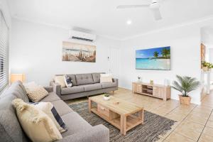 a living room with a couch and a coffee table at Palm Cove House in Trivia in Palm Cove