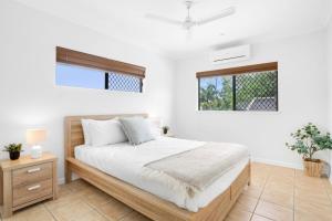 a bedroom with a large bed and a window at Palm Cove House in Trivia in Palm Cove