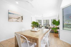 a dining room with a wooden table and chairs at Palm Cove House in Trivia in Palm Cove