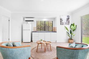 a kitchen with two chairs and a table and a refrigerator at Palm Cove House in Trivia in Palm Cove
