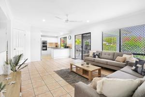 a living room with a couch and a table at Palm Cove House in Trivia in Palm Cove