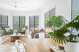 a living room with chairs and a table with a plant at Palm Cove House in Trivia in Palm Cove