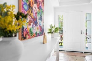 a living room with flowers and a painting on the wall at Palm Cove House in Trivia in Palm Cove