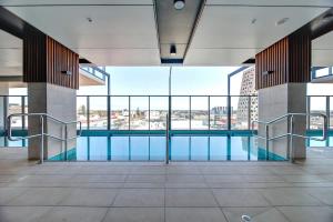 einen Pool in einem Gebäude mit großen Fenstern in der Unterkunft High-Rise Heaven - West Franklin in Adelaide