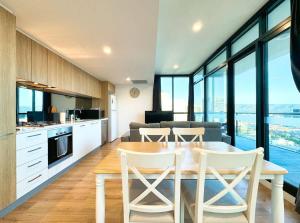 eine Küche und ein Wohnzimmer mit Tisch und Stühlen in der Unterkunft High-Rise Heaven - West Franklin in Adelaide
