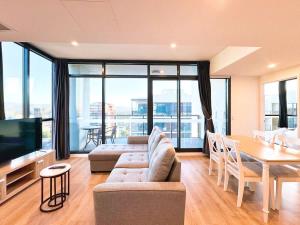 ein Wohnzimmer mit Sofa und Tisch in der Unterkunft High-Rise Heaven - West Franklin in Adelaide