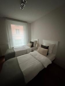 due letti in una stanza con finestra di Le Refuge Historique WIFI - Parking - Confort a Bruxelles