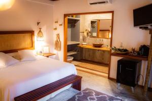 a bedroom with a bed and a bathroom with a tub at Aloha Village Hotel in Icaraí