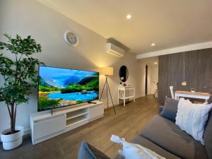a living room with a large flat screen tv at Queen Bed Luxury Parisian Paradise with Amazing City Views & Gym in Adelaide