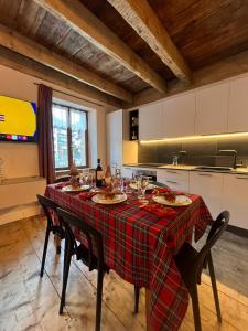 a kitchen with a table with plates and wine glasses at Appartamento Zeli e Old Alagna in Alagna Valsesia