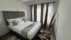 a bedroom with a large bed with a window at Sonrise Stays in Gaborone