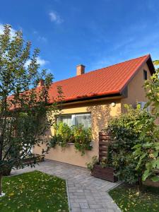 a house with a red roof and a garden at Janka Apartman in Siófok
