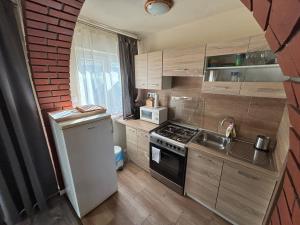 a small kitchen with a stove and a sink at Janka Apartman in Siófok