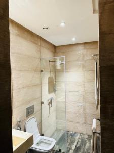 アガディールにあるHotel STAY INNのトイレとガラスのシャワー付きのバスルーム