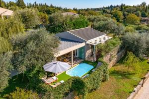 una vista sul tetto di una casa con piscina e ombrellone di Villa Oras Corfu Dionisos by Villa Plus a Dassia