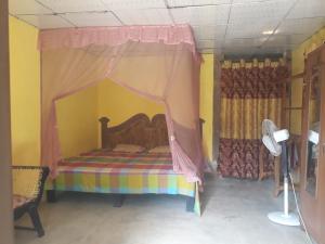 韦利格默Cinnamon Garden的一间卧室，里面有一张带帷幔的床