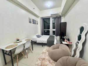 a bedroom with a bed and a table and chairs at The Wild Roces Makati, The Beacon Residences in Manila +7 photos