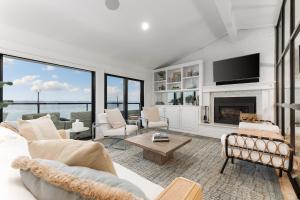 een woonkamer met een bank en een open haard bij Water’s Edge Private Frontage + Dock Hot Tub AC in Traverse City