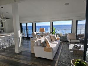 een woonkamer met een witte bank en een keuken bij Water’s Edge Private Frontage + Dock Hot Tub AC in Traverse City