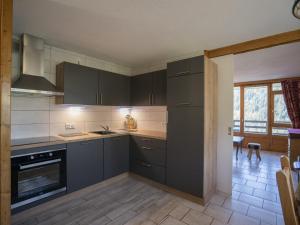 eine Küche mit grauen Schränken und einem Herd mit Backofen in der Unterkunft Châtel : Appartement 2 pièces, 5 pers, proche centre et remontées, balcon exposé S/O, classé 3* - FR-1-676-90 in Châtel + 2 Fotos