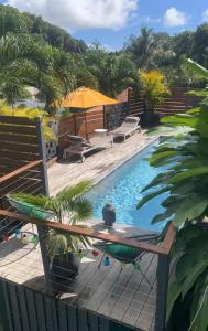 a pool with a table and chairs next to a fence at T2 Beausoleil in Les Abymes