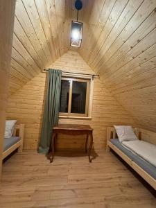 a room with two beds and a window in a wooden cabin at Chata na Wzgórzu in Ochotnica Dolna