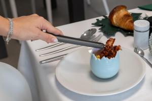 a person is putting food in a bowl on a table at B&B I LAKE IT BELLAGIO in Bellagio