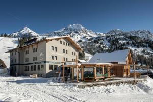 budynek w śniegu z górami w tle w obiekcie Das Wismeyer - Skihotel an der Plattenkarbahn w mieście Obertauern