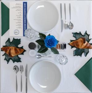 a table topped with white plates and silver utensils at B&B I LAKE IT BELLAGIO in Bellagio