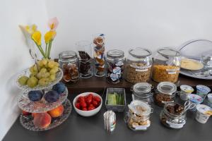 a table topped with bowls of fruit and jars of food at B&B I LAKE IT BELLAGIO in Bellagio