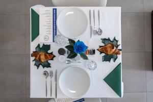 a table with white plates and utensils on a table at B&B I LAKE IT BELLAGIO in Bellagio
