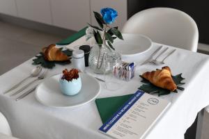 a white table topped with plates of food and flowers at B&B I LAKE IT BELLAGIO in Bellagio