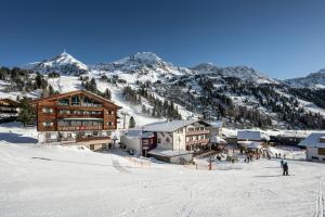 domek narciarski na szczycie pokrytej śniegiem góry w obiekcie AUSTRIA APPART - natural Lifestyle Appartements auf der Piste w mieście Obertauern